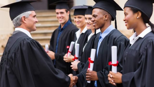 Professor handshaking a PhD graduate student on graduation ceremony